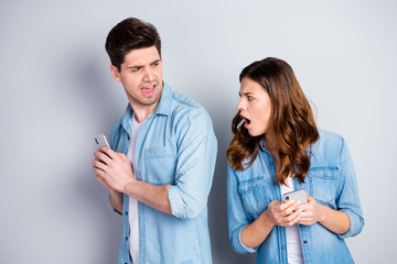 Sticker - Portrait of frustrated crazy girl use smartphone see her boyfriend chatting with cute woman she scream he hide device wear casual fashion jeans isolated over gray color background