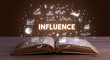 INFLUENCE inscription coming out from an open book, business concept