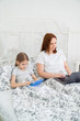 © andrey - daughter and mom play on computer in bed