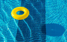 Yellow Pool Float, Ring Floating In A Refreshing Blue Swimming Pool