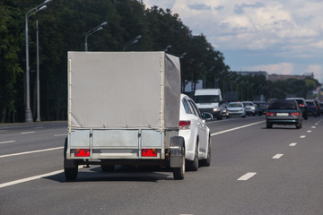 Wall Mural - car with a trailer moves on a city