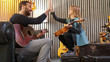© ZoneCreative - Dad giving five to his daughter celebrating success while teaching music to his daughter.Little girl learning guitar at home.Side view.Ukulele class at home. Child learning guitar from her father
