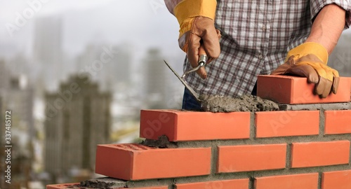 Fotomural Man worker installing brick masonry wall with a trowel