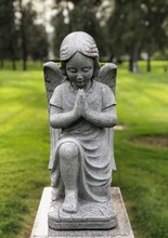 Close Up View Of Memorial Angel Statue Praying At The Cemetery