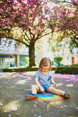 Wall Mural - toddler girl drawing rainbow with colorful chalks