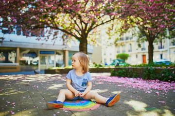 Wall Mural - toddler girl drawing rainbow with colorful chalks