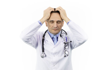 Wall Mural - Handsome middle aged doctor in white medical gown with hand on head for headache because stress. Surgeon suffers from migraine. Tired after a hard day. Isolated white background