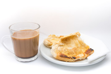 Popular brazilian bread with melted butter called pao na chapa. Pao na chapa traditional brazilian breakfast. Glass of hot coffee with milk called pingado. 