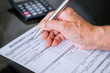 © Creativa Images - Old man hand filling retirement claim application