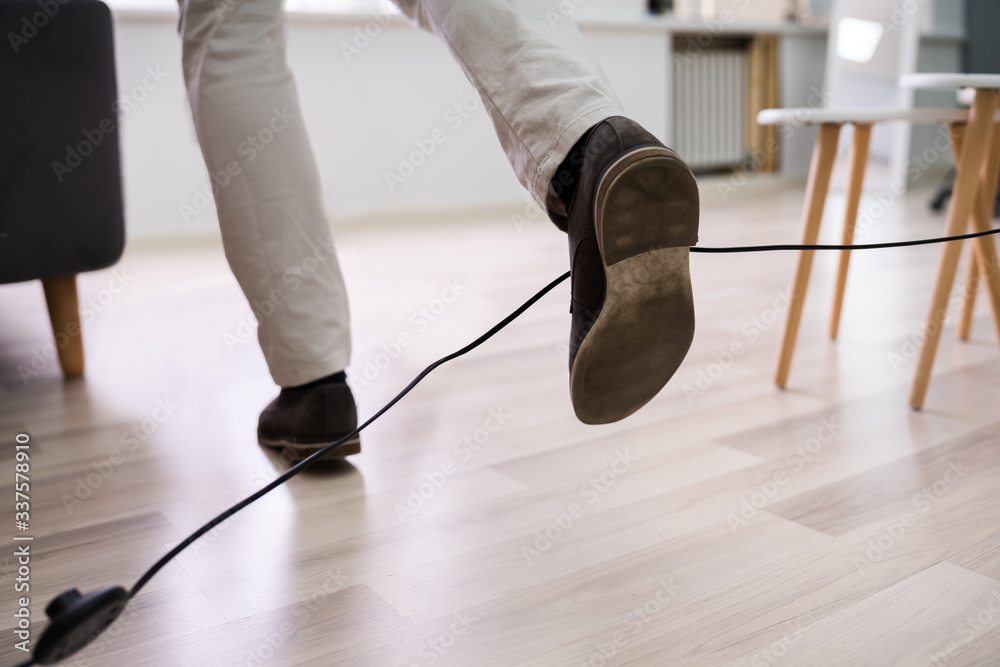 Man Legs Stumbling With An Electrical Cord - obrazy, fototapety, plakaty 
