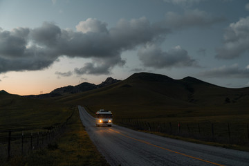 Wall Mural - bus driving on rural road during sunset