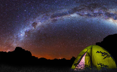 Tent under the with forest near in the mountains . abstract camping and glowing under the milky way  background