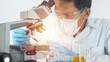 © Baby2M - Scientist working with microscope in lab. Laboratory research concept..About experimental science such as chemical mixing or data entry to develop vaccines for everyone in the world.