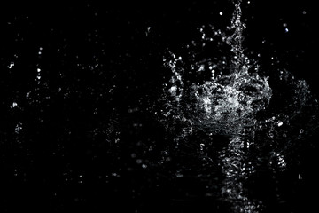  Splashes and drops of water are on a black background.