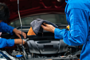 Hands of car mechanic in auto repair service.Car Mechanic Detailed Vehicle Inspection. Auto Service Center Theme. 