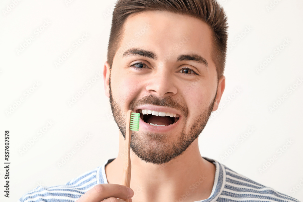 Happy smiling young man with tooth brush on white background