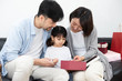 © 浩然 张 - Young Asian mom and dad are unpacking gifts with their daughter