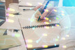 © peshkova - Multi exposure of hands making notes with world map hologram and data theme icons. Concept of global computer data.