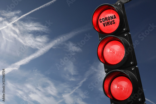 Cuadros en Lienzo Semaforo con tre luci rosse accese e scritta corona virus su cielo azzurro con