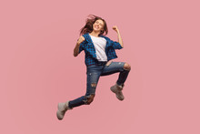 Full Length Of Overjoyed Ecstatic Stylish Girl Jumping In Air, Gesturing I Did It, Celebrating Success, Flying And Rejoicing Her Dream Achievement. Indoor Studio Shot Isolated On Pink Background