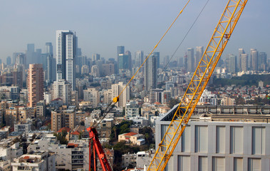 Modern city. Office building top view. Crane and building construction site against the blue sky. Isreal, Ramat Gan, Bnei Brak, Tel Aviv, Tel Aviv-Yafo