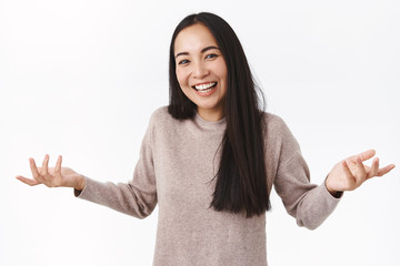 Not big deal, relax. Joyful and careless unbothered good-looking asian woman shrugging and spread hands sideways, dont know how he got first prize, cant answer, standing clueless white background