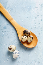 Quail Eggs In A Wooden Spoon On A Blue Background