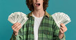 © Prostock-studio - Winning lottery. Happy young guy with money shouting OMG on turquoise background, closeup. Panorama
