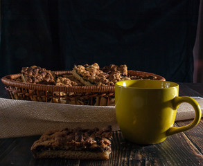 Cup of coffee and cookies on a dark background.