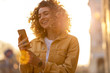 © pikselstock - Young hipster woman using smartphone at sunset