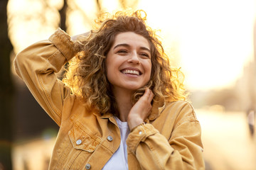 portrait of young woman with curly hair in the city