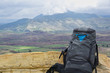 Close-up of a black backpacker's backpack against the backdrop of the Maragua volcanic crater in the Bolivian altiplano.