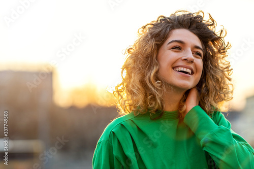 Fotomural Portrait of young woman with curly hair in the city