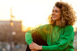 © pikselstock - Portrait of young woman with curly hair in the city
