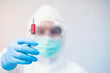 © ittipol - doctor in personal protective equipment or PPE. holding vaccine syringe,Coronavirus covid-19 outbreak concept
