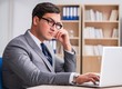 © Elnur - Young businessman sitting at the desk