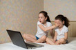Little girl protects his sister from watching inappropriate content while using a computer. Internet safety for kids concept.
