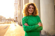 © pikselstock - Portrait of young woman with curly hair in the city