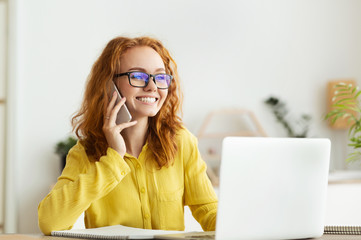 Poster - Woman talking on smart phone, working on laptop at home