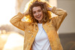 © pikselstock - Portrait of young woman with curly hair in the city