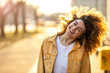 © pikselstock - Portrait of young woman with curly hair in the city