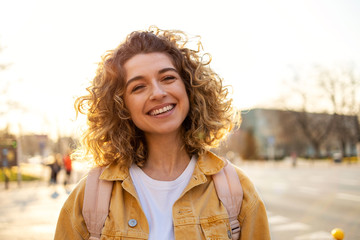 portrait of young woman with curly hair in the city