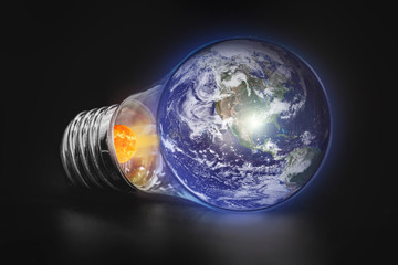 energy concept - save energy, planet earth in a light bulb on a black background