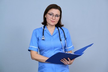 Portrait of mature nurse woman holding clipboard