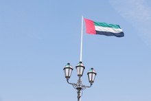 Low Angle View Of Uae Flag Against Blue Sky