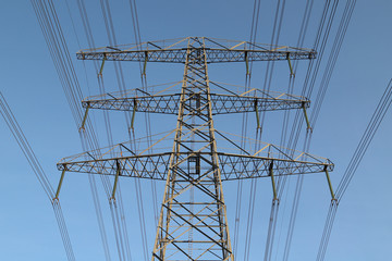 Row electricity pylon power tower landscape at sunset