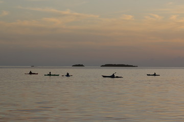 Canvas Print - people boating in the bay at sunset