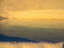 Rock Formation Reflecting On Travertine Pool At Pamukkale