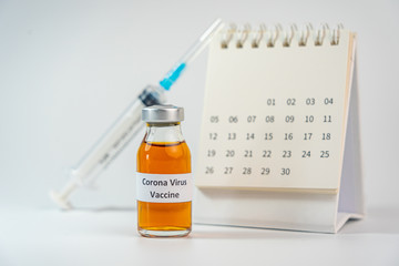 Wall Mural - Coronavirus vaccine bottle and syringe injection next to 2020 calendar 