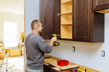 Wall Mural - Installation of furniture hinges on the cabinet door